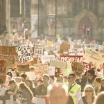 A hazy photo of a large crowd of protesters at a rally organised by climate strikers.